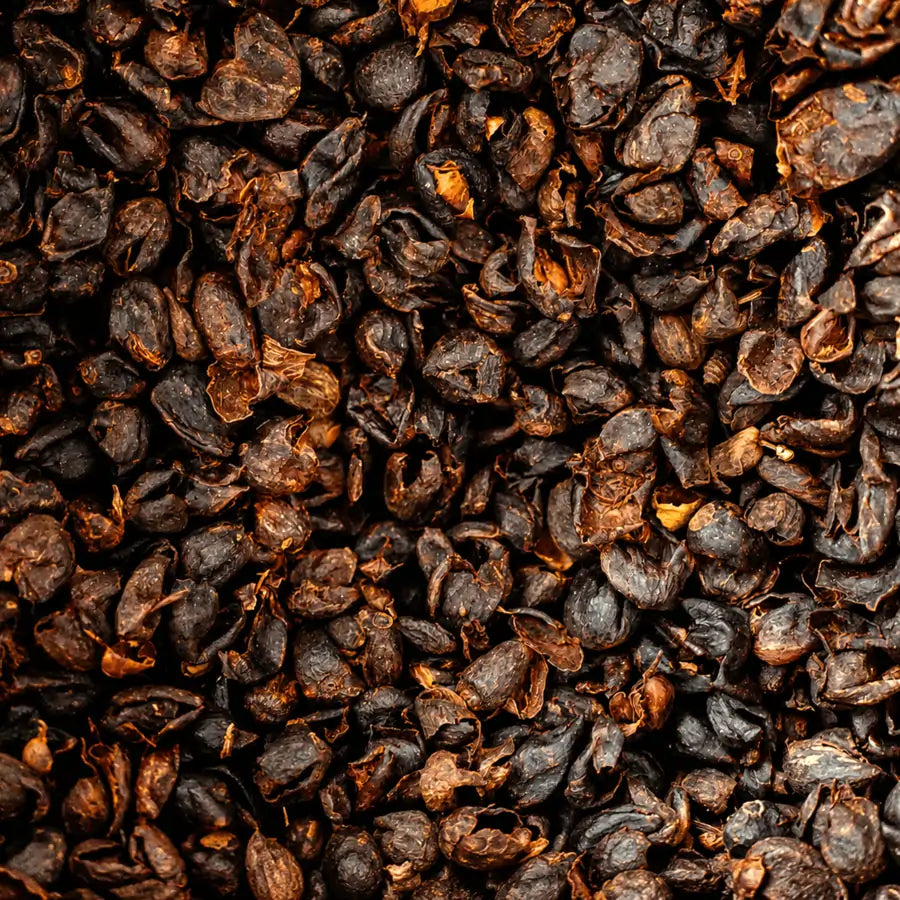 Zbliżenie na suszone łupiny owoców kawowca (cascarę) o naturalnej, chrupiącej strukturze – surowiec wykorzystywany do przygotowania naparu i syropu cascara.