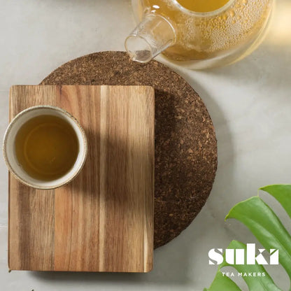 Herbata ziołowa Lemongrass & Ginger SUKI Tea – filiżanka zaparzonej herbaty z imbirem i trawą cytrynową na drewnianej desce, widok z góry