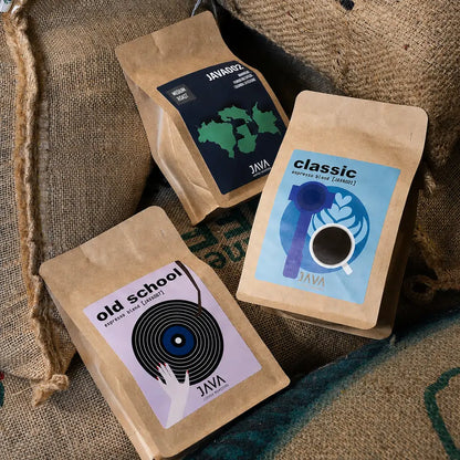 Kawy espresso JAVA Coffee Roasters – Classic, Old School i JAVA002 na workach jutowych z zieloną kawą w palarni kawy specialty.