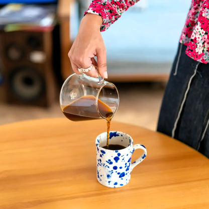 Parzenie kawy przelewowej – świeżo zaparzona kawa nalewana z szklanego dzbanka do ceramicznej filiżanki, ujęcie lifestyle