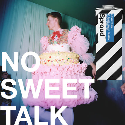 Karton Sproud Unsweetened obok osoby w teatralnej sukni w kształcie tortu – kampania napoju roślinnego bez cukru z hasłem „No sweet talk”.