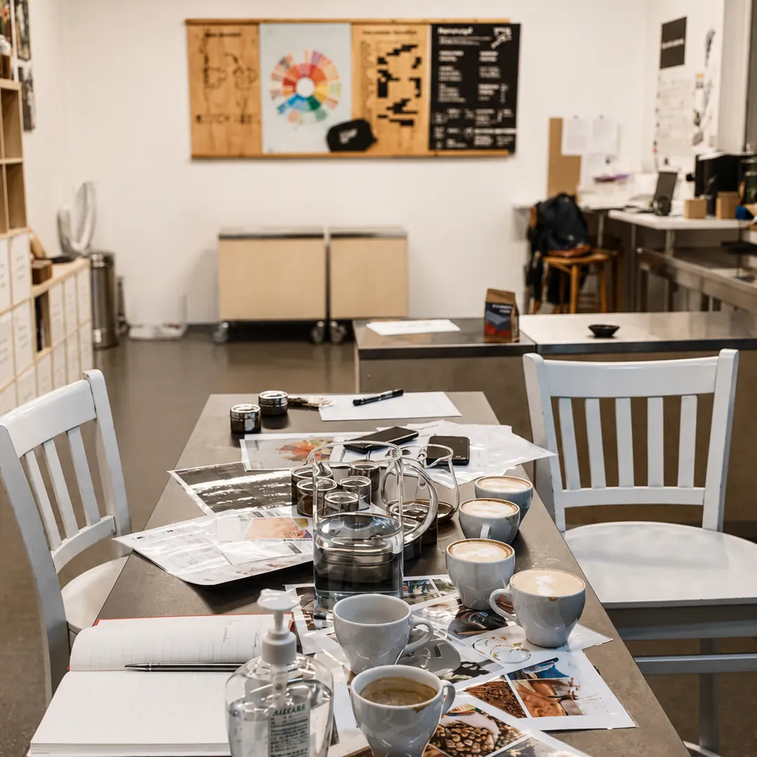 Stanowisko szkoleniowe przygotowane do nauki parzenia kawy metodami przelewowymi i espresso. Filiżanki, akcesoria baristyczne oraz materiały edukacyjne podczas szkolenia baristycznego.