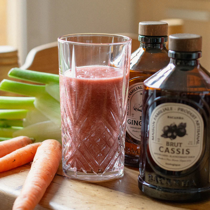  Smoothie z dodatkiem syropu Bacanha z czarnej porzeczki i imbiru, w otoczeniu świeżych marchewek i kopru włoskiego – naturalna kompozycja smaków i kolorów.
