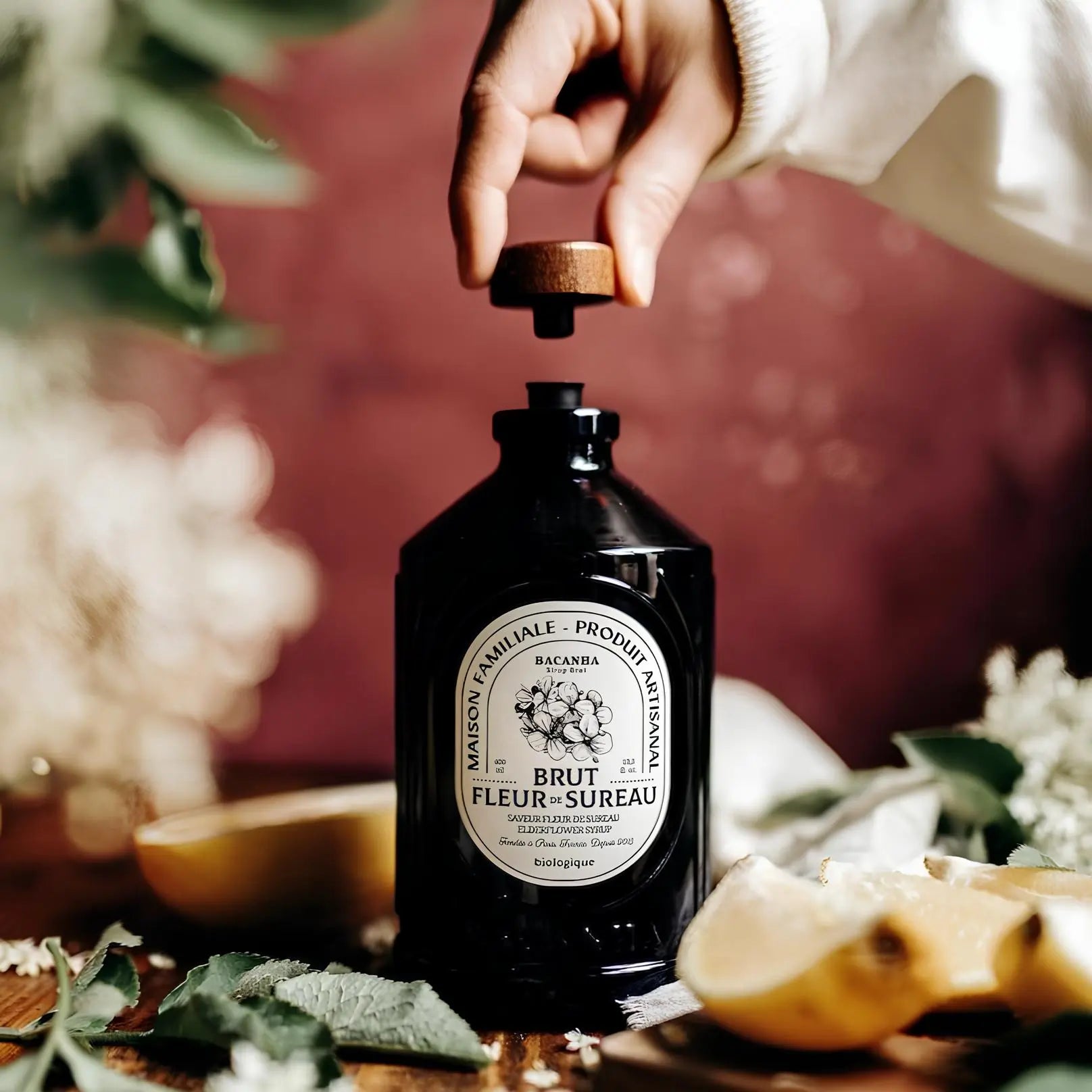 Organiczny francyzski syrop Bacanha o smaku kwiatu czarnego bzu na stole w otoczeniu