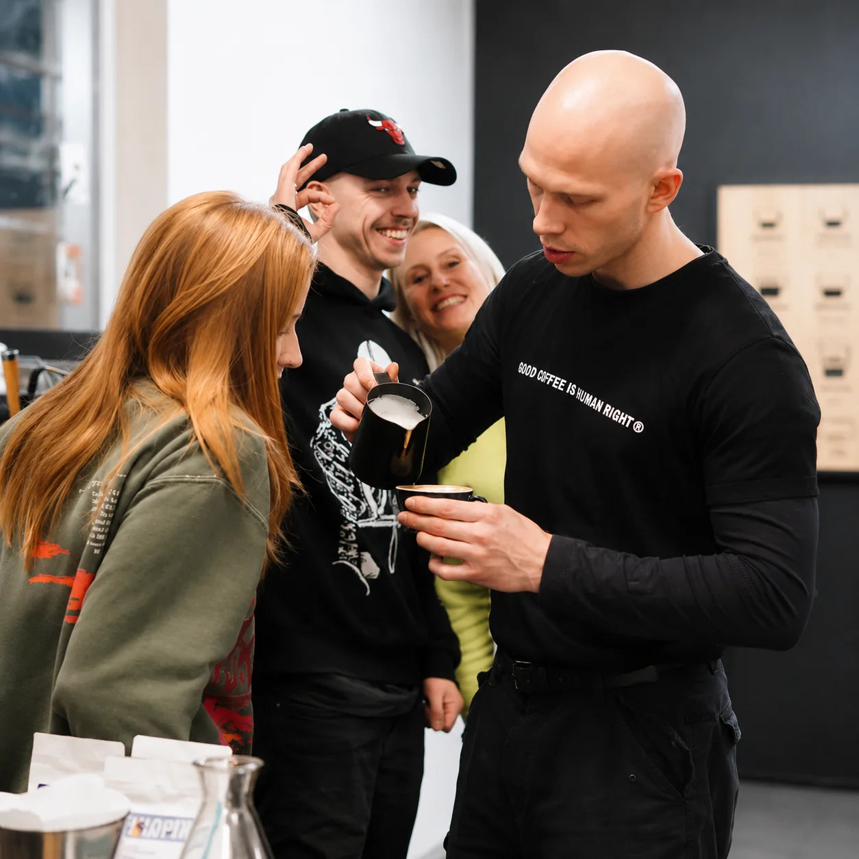 Instruktor prezentuje technikę spieniania mleka i przygotowania latte art podczas praktycznego szkolenia baristycznego. Uczestnicy uczą się prawidłowego nalewania mikropianki do kaw mlecznych.